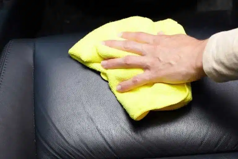 A Man is Cleaning Couch with His Hand