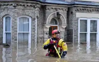 SES man infront flooded old house